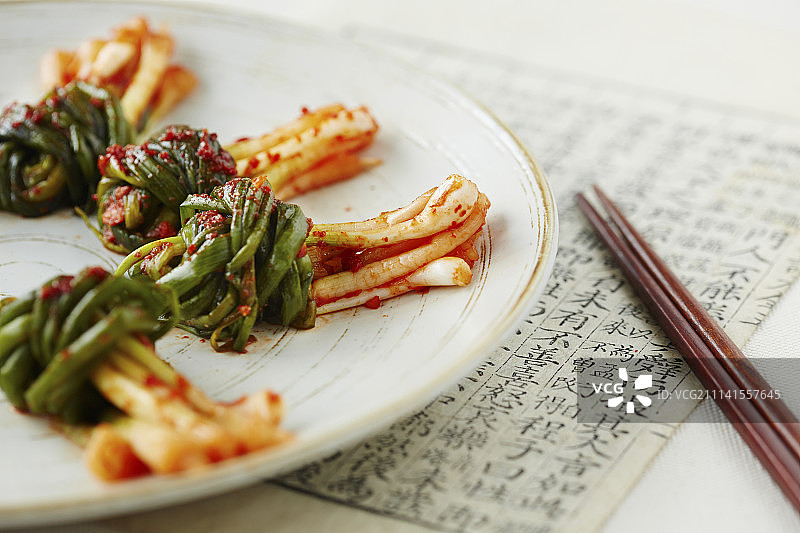 筷子旁边的盘子上的泡菜图片素材