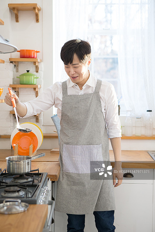 韩国籍，男，厨房(干物质)，烹饪(准备食物)，味觉(工作)，微笑，满意图片素材