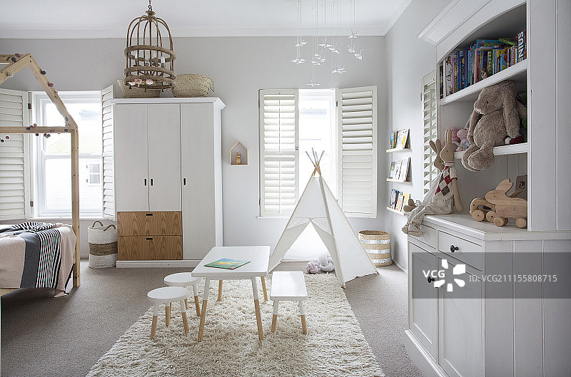 明亮的孩子卧室里有白色的家具和圆锥形帐篷图片素材
