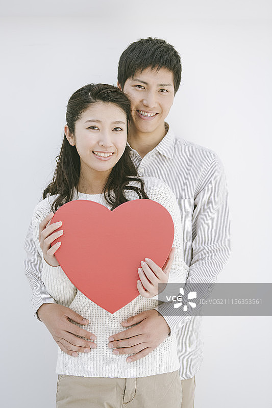 情侣抱着心形站在一起的照片图片素材