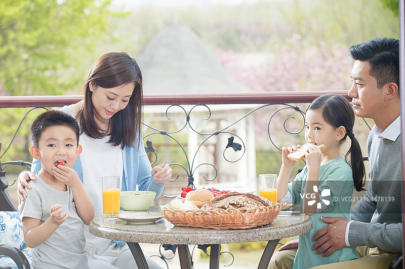 幸福家庭在阳台吃早餐图片素材