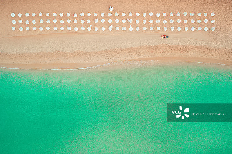 鸟瞰图的海滩。雨伞，沙子和海浪图片素材