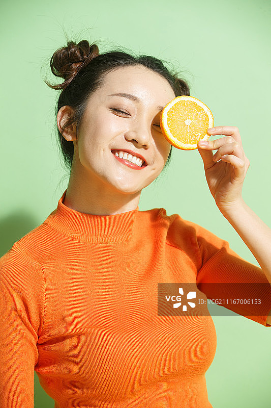 青年女人拿着橙子图片素材