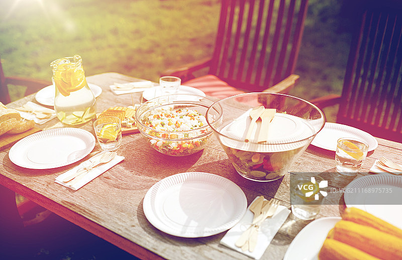 假日，饮食，用餐时间和食物概念-餐桌与晚餐在夏季花园派对。夏季游园会晚餐的餐桌图片素材