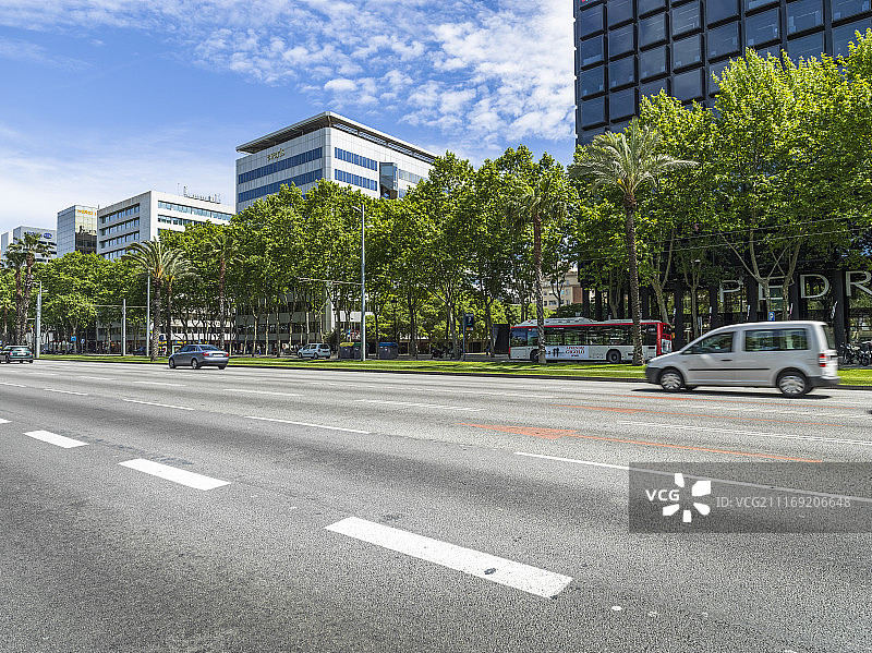 现代城市建筑旁有一条单行道多车道公路图片素材