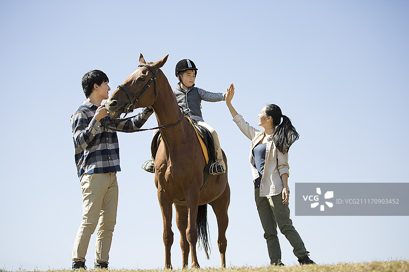 快乐一家人在草地骑马图片素材