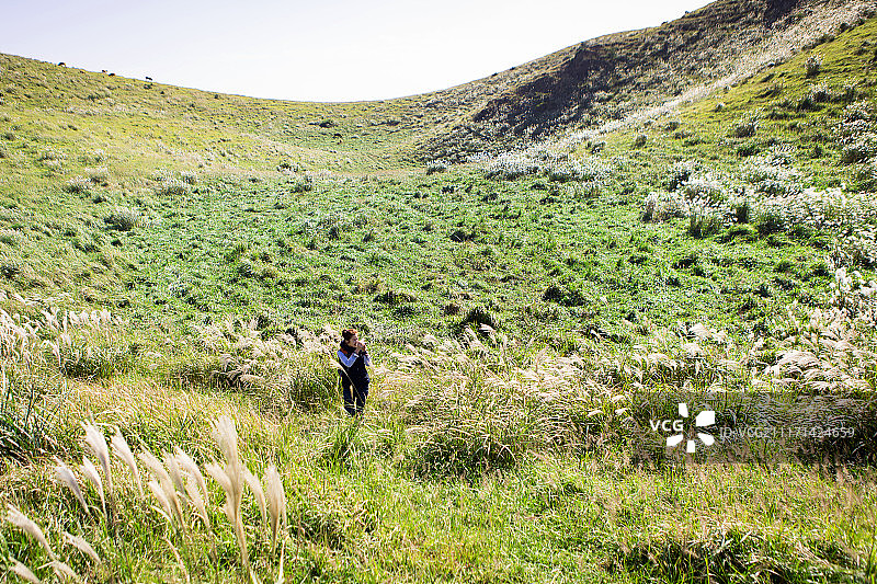 在银色的草地上徒步的女人的摄影图片素材