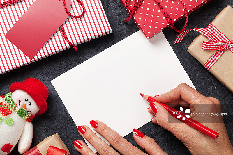 女性写圣诞贺卡和礼物包装图片素材