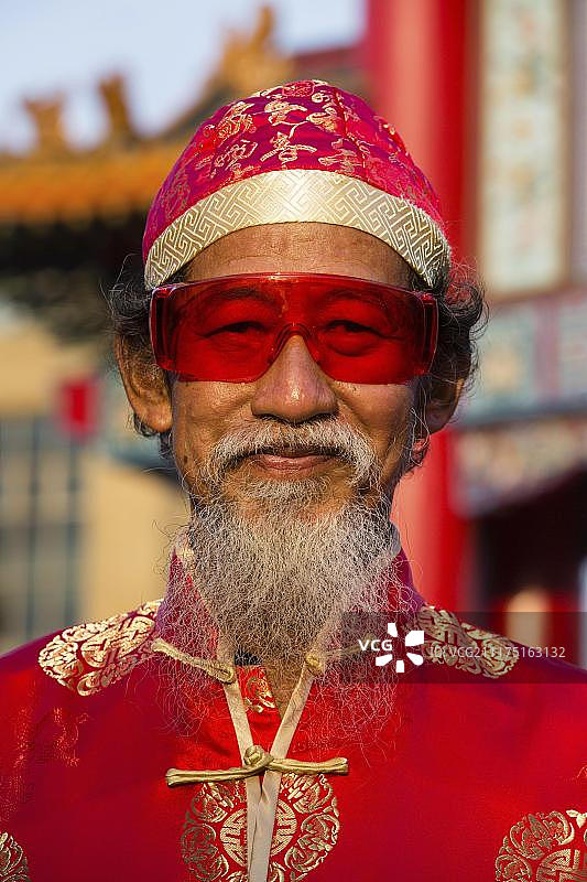 肖像，中国老人戴着红色眼镜，帽子和胡子，中国新年，春节，唐人街，曼谷，泰国，亚洲图片素材