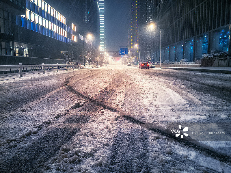 城市中夜晚道路上的雪景图片素材