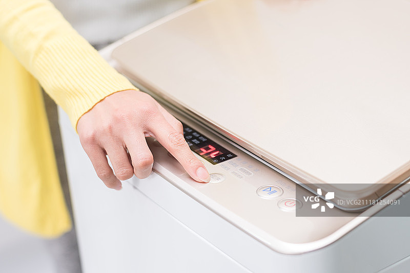 一个人操控洗衣机按键图片素材
