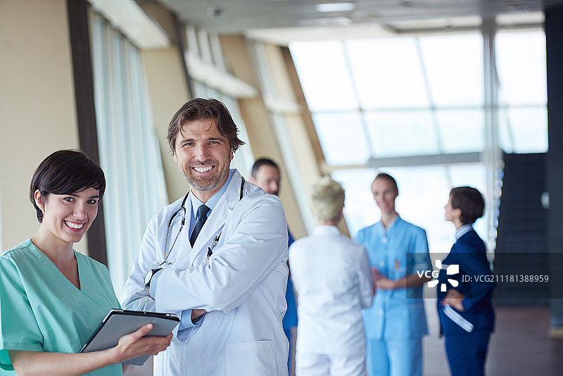一群医务人员在医院里，英俊的医生站在队伍前面，人们聚在一起站在后面图片素材