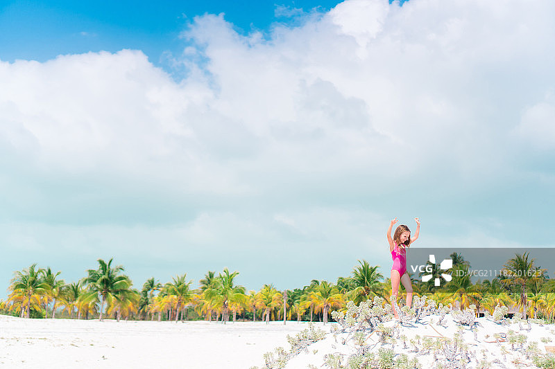 沙滩上的小女孩，背景是棕榈树图片素材