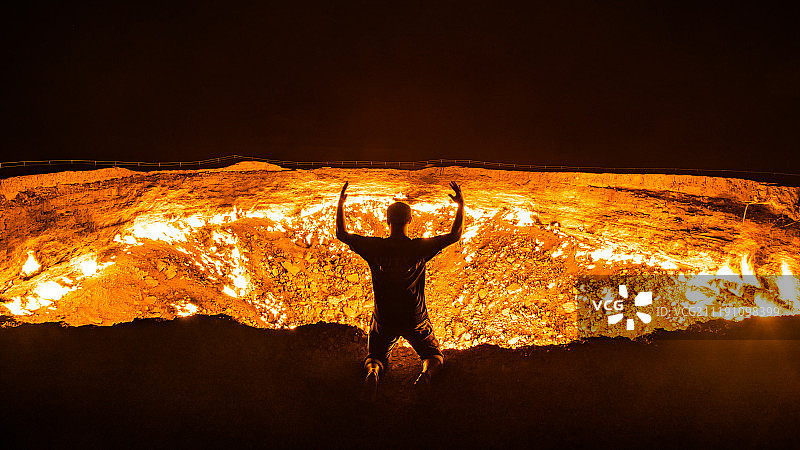 土库曼斯坦火山口跪着的人图片素材