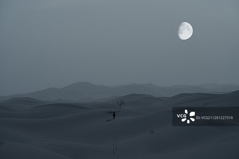 月下沙漠独自行走的人图片素材