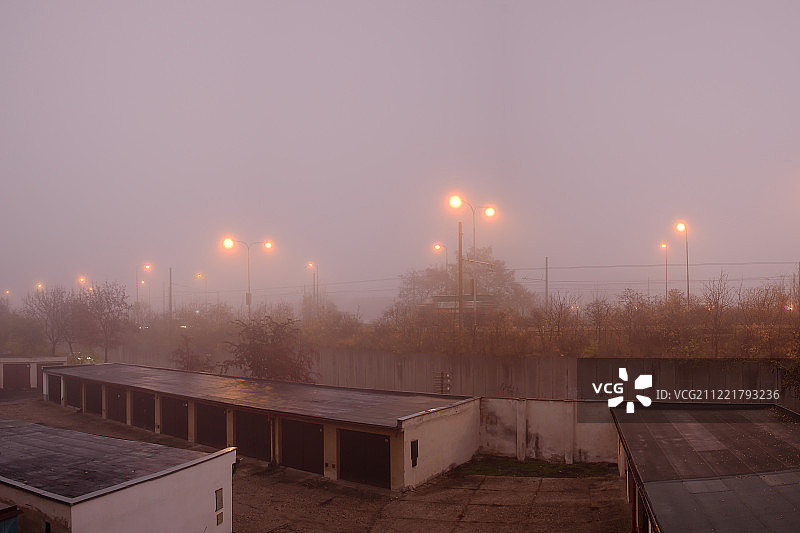 捷克乔穆托夫——2018年11月12日:秋天雾蒙蒙的早晨，车库和路灯图片素材