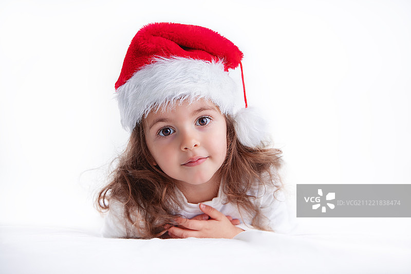 圣诞时间，小女孩在圣诞老人的帽子微笑图片素材