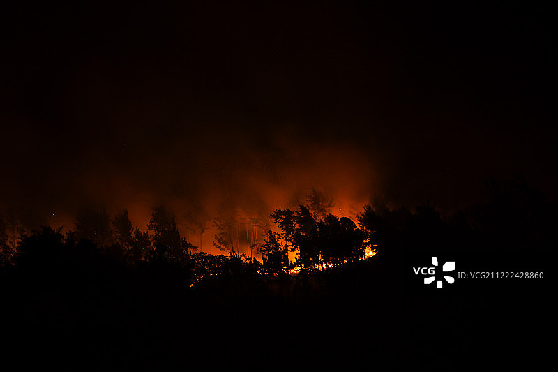 观看山腰上燃烧赤褐色的火焰图片素材