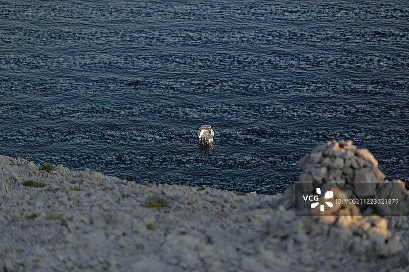 带人的小汽艇，蓝色的海，岩石海岸图片素材
