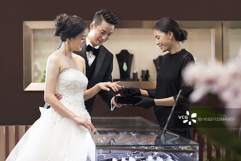 幸福的新娘和新郎在珠宝店挑选戒指图片素材