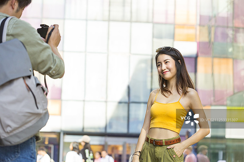 年轻情侣在户外商业街逛街旅游拍照图片素材