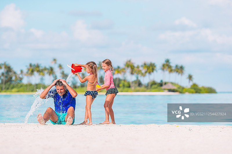 可爱的小女孩玩爸爸在白色沙滩图片素材