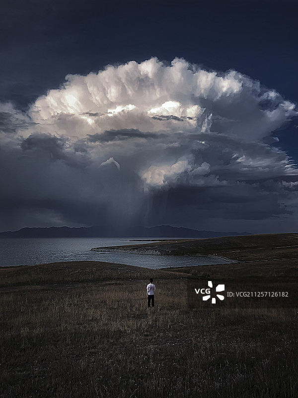 一个人站在奇异形状云下图片素材