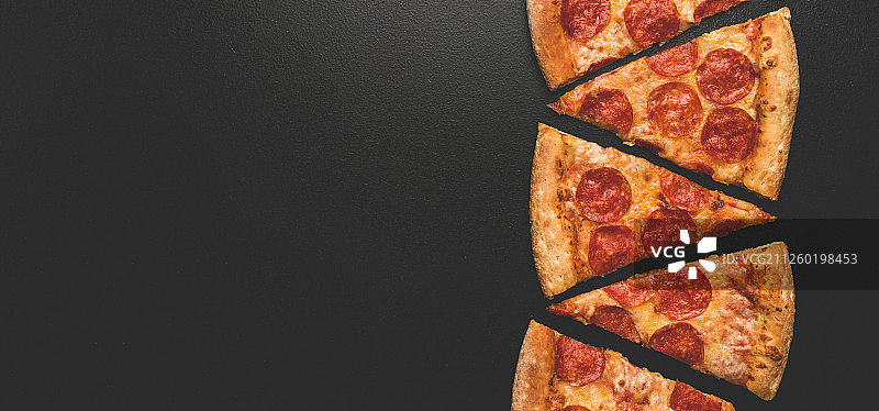 黑色背景上的意大利辣香肠披萨片图片素材