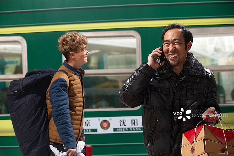 在火车月台上打电话的旅客图片素材