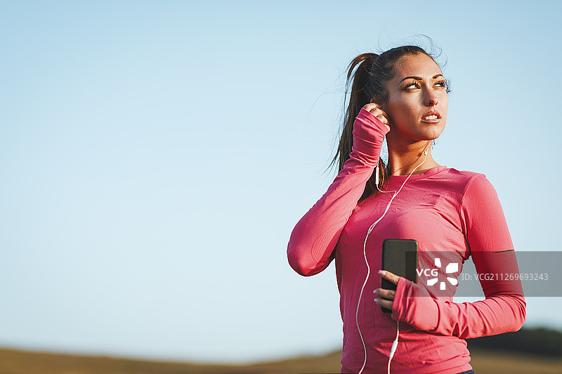 塞尔维亚兹拉蒂博尔，调整耳机的女性慢跑者图片素材