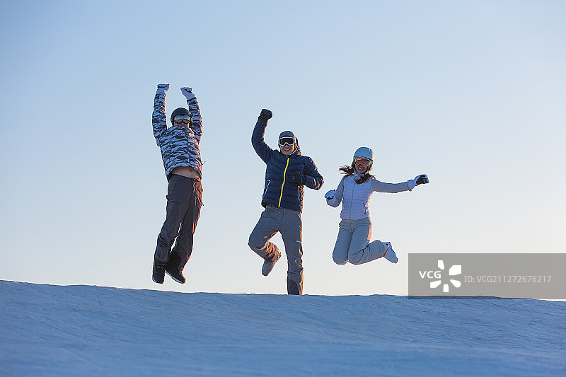 三个青年男女在户外滑雪 场跳跃欢呼庆祝胜利图片素材