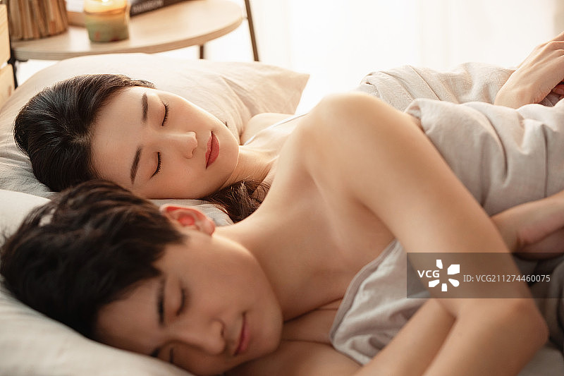 年轻情侣在床上睡觉图片素材
