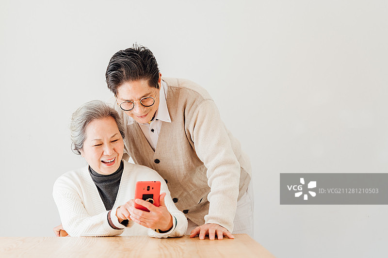 亚洲老年夫妇在家使用智能手机图片素材