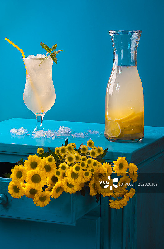冰柠檬水杯和黄花花束图片素材