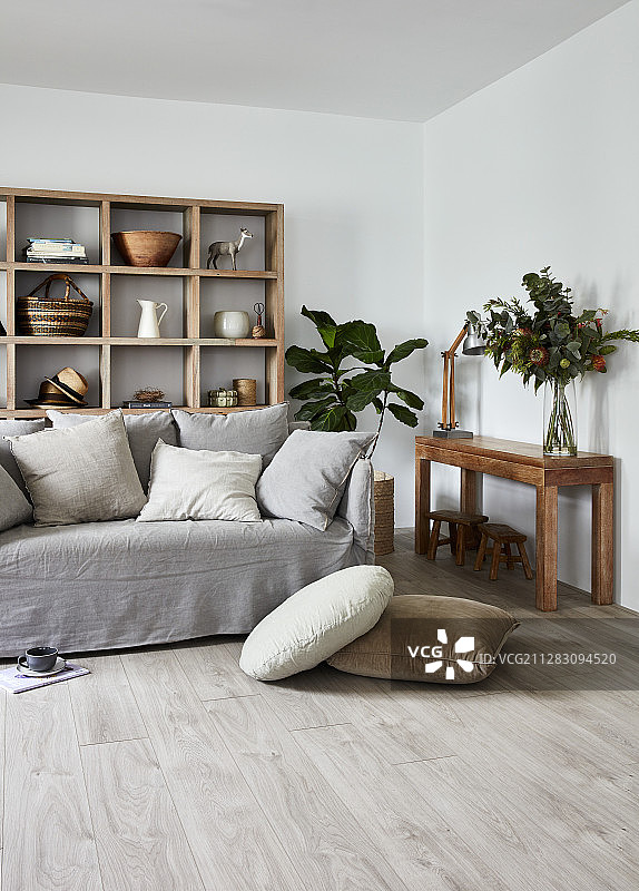 客厅木架前摆放着灰色松套沙发和散落的靠垫图片素材