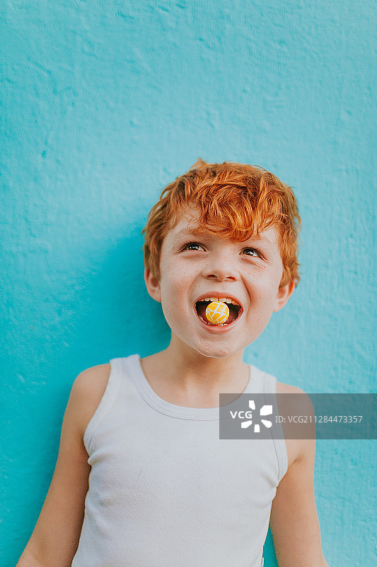 巴西里约热内卢，一个红头发的小男孩，嘴里嚼着口香糖图片素材