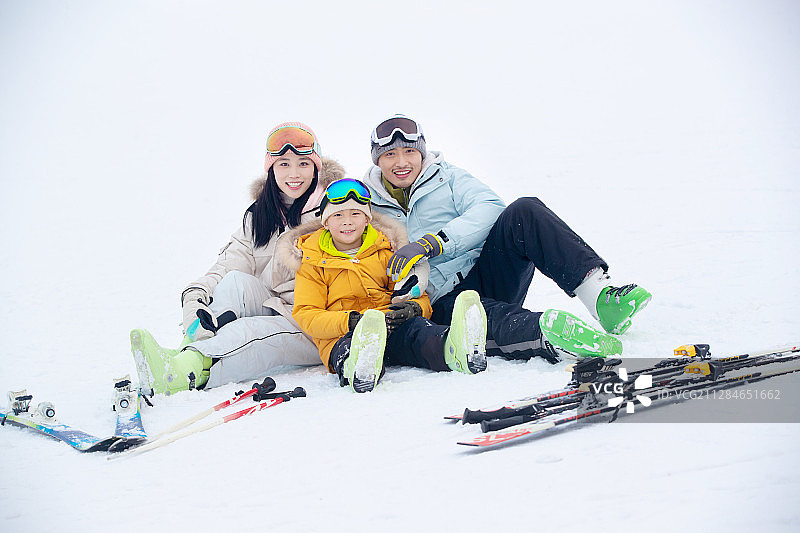 坐在雪地上幸福的一家三口图片素材