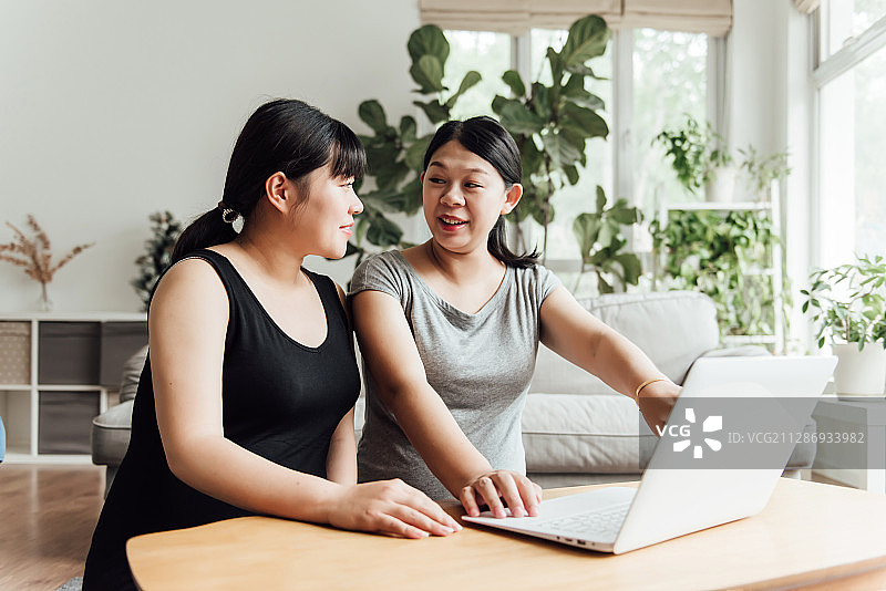 两位年轻的亚洲孕妇正在使用电脑图片素材