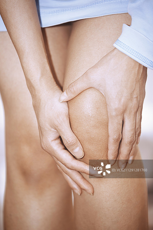女人用手抓住她疼痛的膝盖图片素材