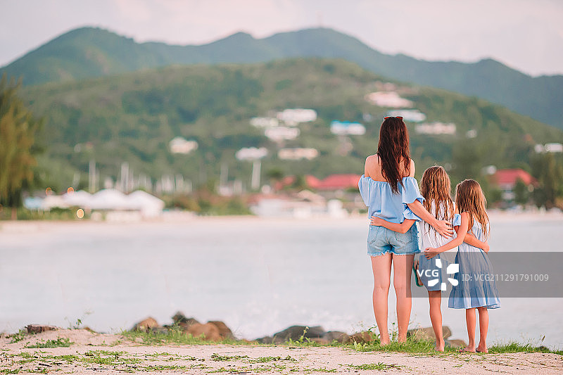 母亲和两个女儿在热带海滩上图片素材