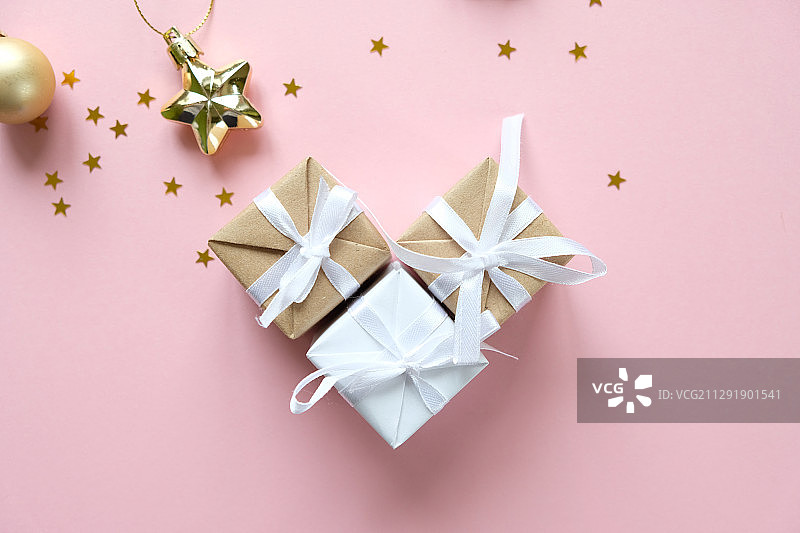 粉红色背景的圣诞装饰品和礼品盒图片素材
