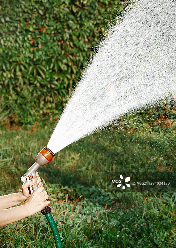 做园艺工作和用软管浇水的女人图片素材