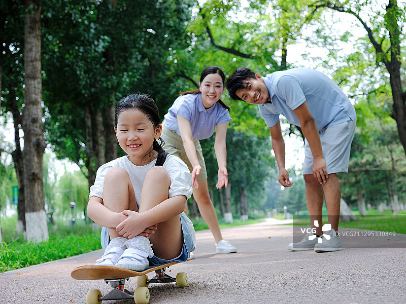 快乐的三口之家玩滑板图片素材