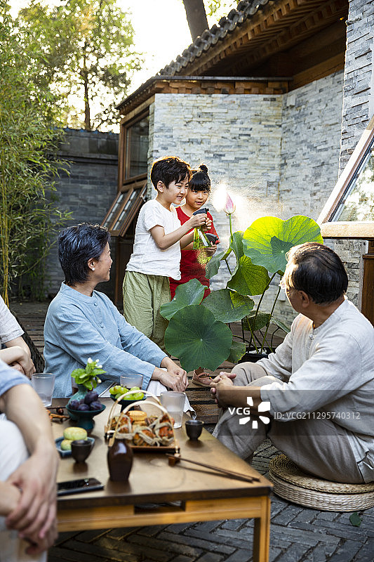 中秋节一家六口在户外庭院聚餐嬉戏玩耍图片素材
