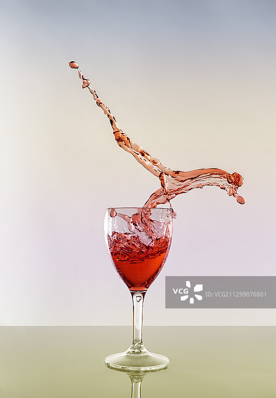 特写:白色背景下，红酒在玻璃杯中泼洒，安南，英国图片素材
