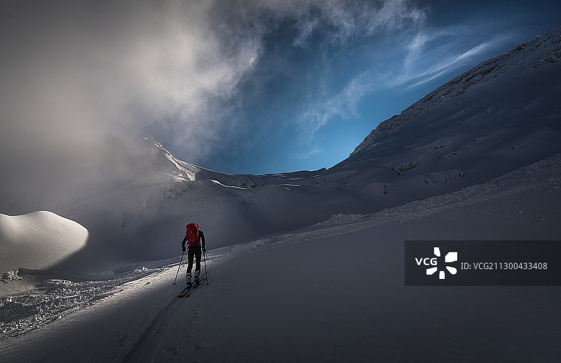 后视图的人滑雪雪山对天空，Bovec，斯洛文尼亚图片素材