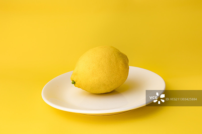 阿塞拜疆巴库，黄色背景下的盘子里的柠檬特写图片素材