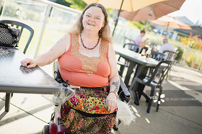 在户外餐厅坐轮椅的白人妇女，Silverdale，华盛顿，美国图片素材
