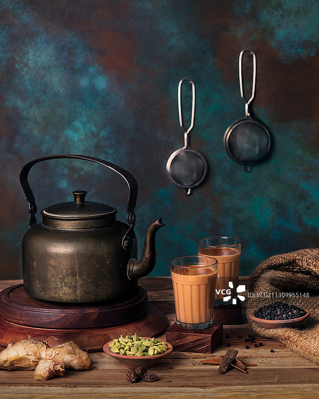 近距离的印度茶与水壶和配料在桌子上图片素材
