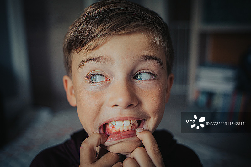 年轻的白人男孩炫耀最近失去的牙齿，莉娜，伊利诺斯州，美国图片素材